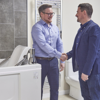 two men shaking hands in a bathroom